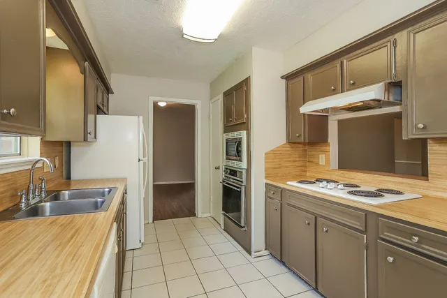 a kitchen that has a sink stainless steel appliances a counter space and cabinets