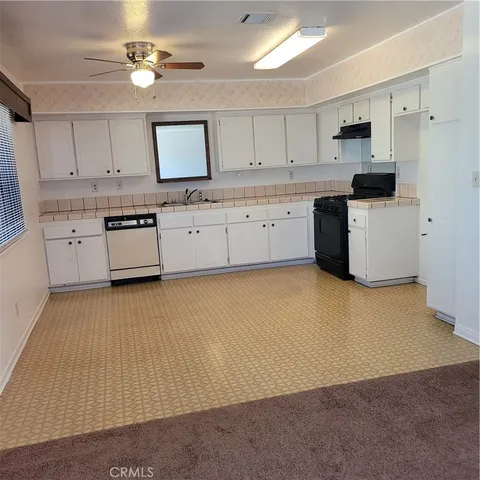 a kitchen with granite countertop a stove a sink dishwasher and a refrigerator with wooden floor