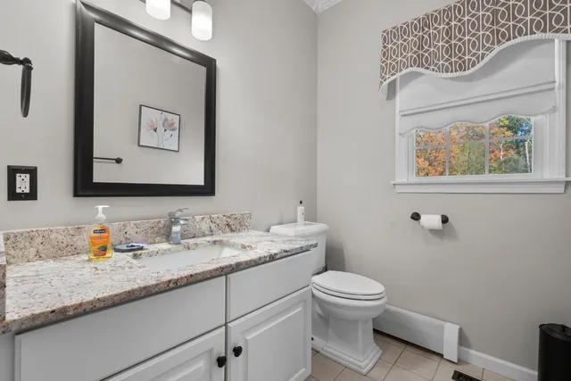 a bathroom with a granite countertop toilet a sink and mirror