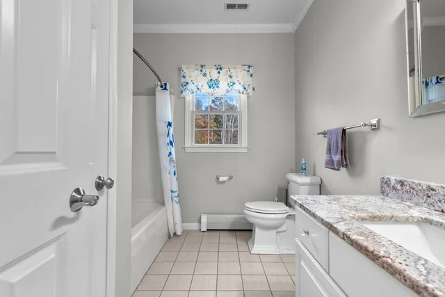 a bathroom with a granite countertop sink a toilet and shower