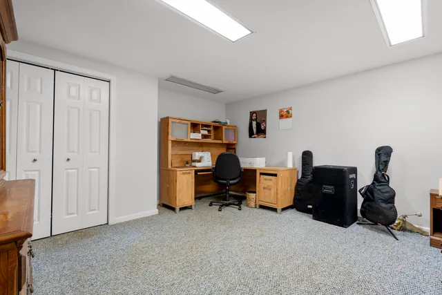 a view of a workspace with furniture and a window