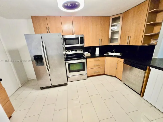 a kitchen with stainless steel appliances a refrigerator sink and stove