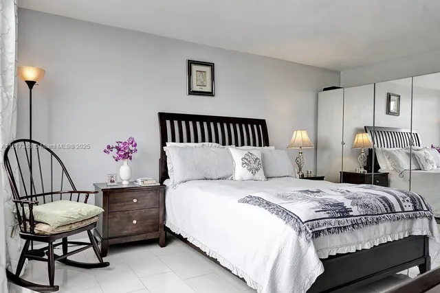 a bedroom with a bed and dresser with mirror