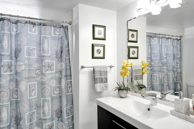 a bathroom with a double vanity sink a mirror a shower and a bathroom