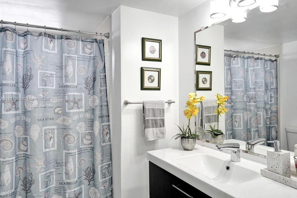 1780 Northeast 191st Street, Unit 4092 Miami, FL 33179 - Photo 13 of 22 a bathroom with a double vanity sink a mirror a shower and a bathroom