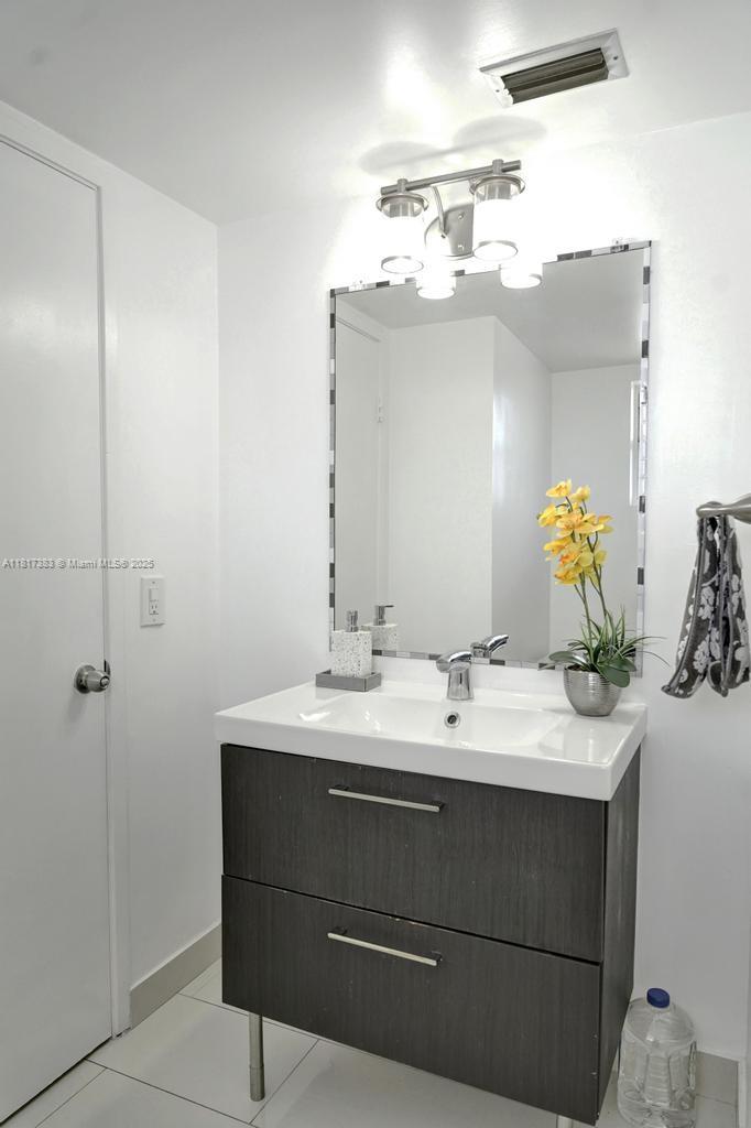 1780 Northeast 191st Street, Unit 4092 Miami, FL 33179 - Photo 14 of 22 a bathroom with a sink vanity and mirror