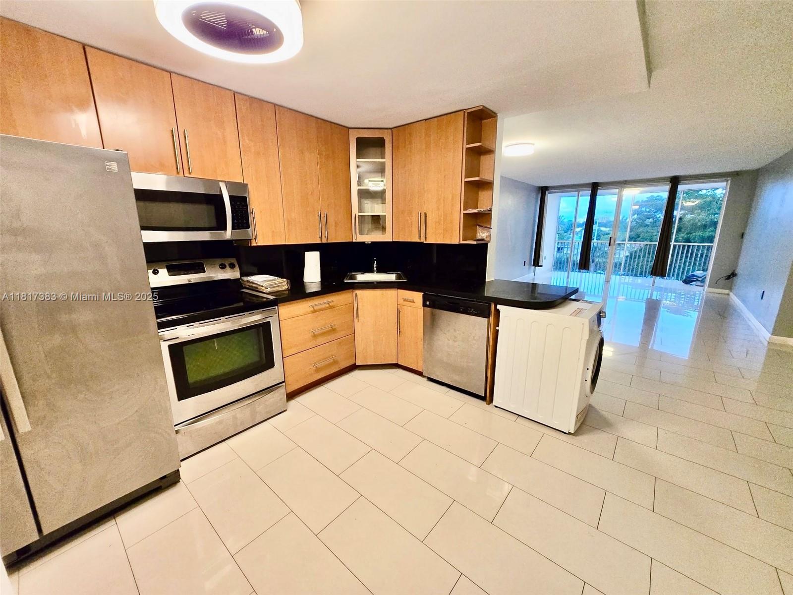 1780 Northeast 191st Street, Unit 4092 Miami, FL 33179 - Photo 2 of 22 a kitchen with stainless steel appliances a stove a sink and a microwave