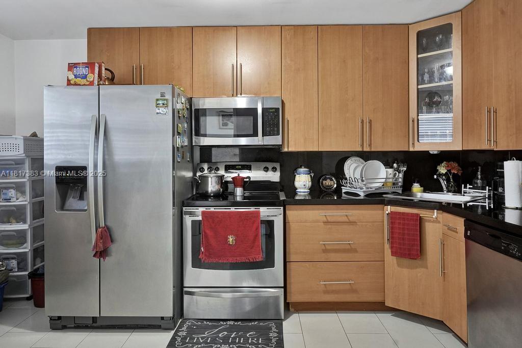 1780 Northeast 191st Street, Unit 4092 Miami, FL 33179 - Photo 7 of 22 a kitchen with stainless steel appliances granite countertop a refrigerator stove and sink
