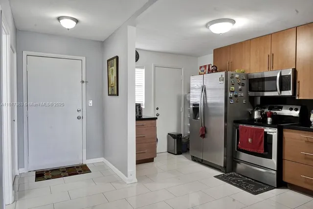 a kitchen with stainless steel appliances granite countertop a refrigerator and a stove top oven