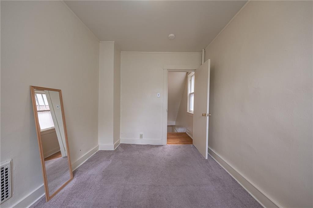 7315 Whipple Street Pittsburgh, PA 15218 - Photo 13 of 24 an empty room with mirror and a bathroom