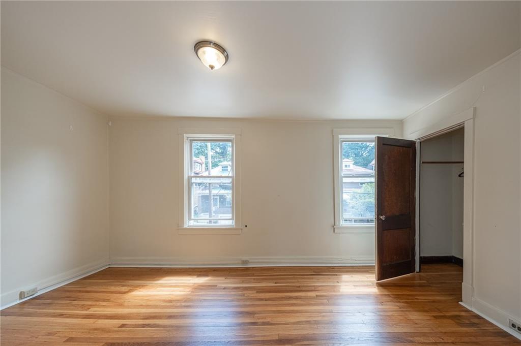 7315 Whipple Street Pittsburgh, PA 15218 - Photo 18 of 24 an empty room with wooden floor and windows