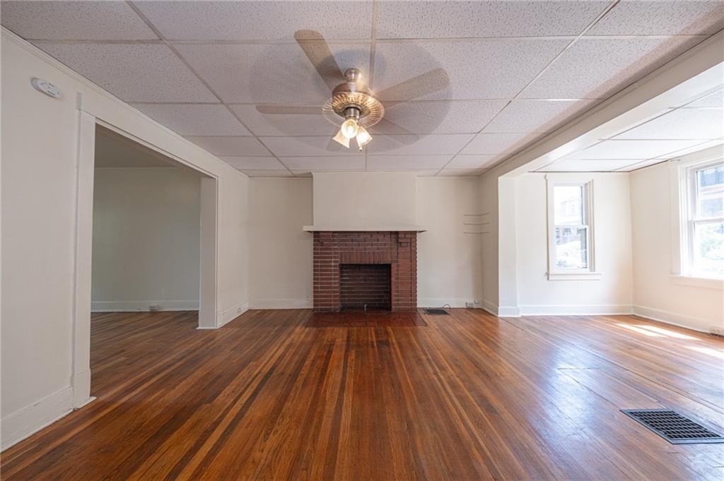 7315 Whipple Street Pittsburgh, PA 15218 - Photo 4 of 24 an empty room with windows and a fireplace