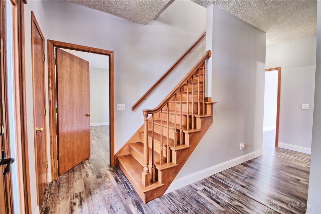 8711 Nicole Lane Springboro, OH 45066 - Photo 30 of 87 This interior image showcases a beautifully crafted wooden staircase with a sleek flooring that complements the design.