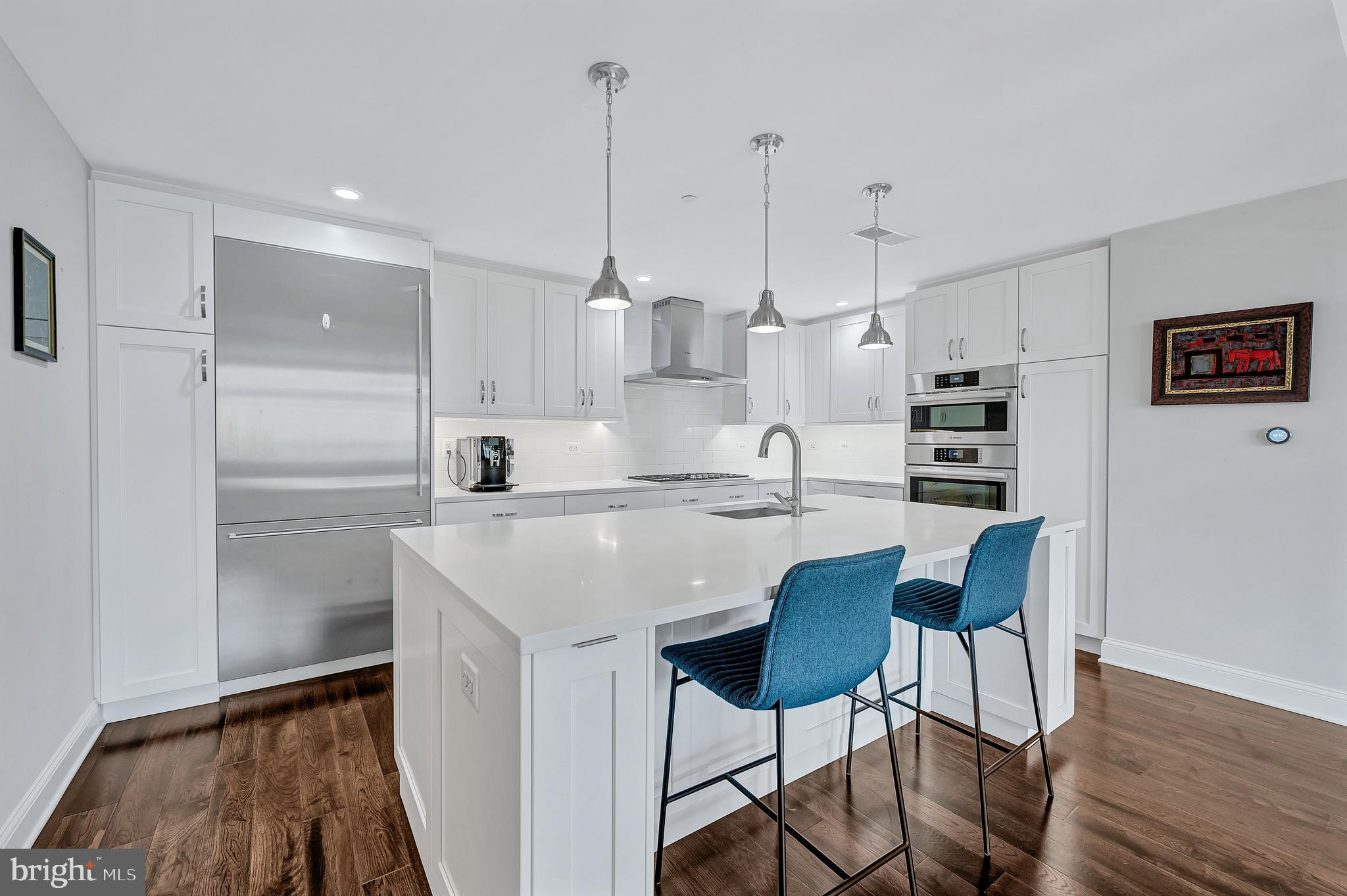 4915 Hampden Lane, Unit 204 Bethesda, MD 20814 - Photo 12 of 31 a kitchen with kitchen island white cabinets and stainless steel appliances