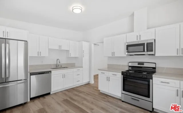 a kitchen with stainless steel appliances a stove sink and microwave