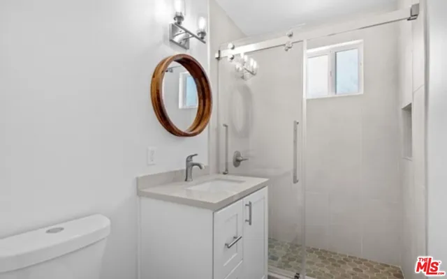 a bathroom with a sink a toilet and a mirror