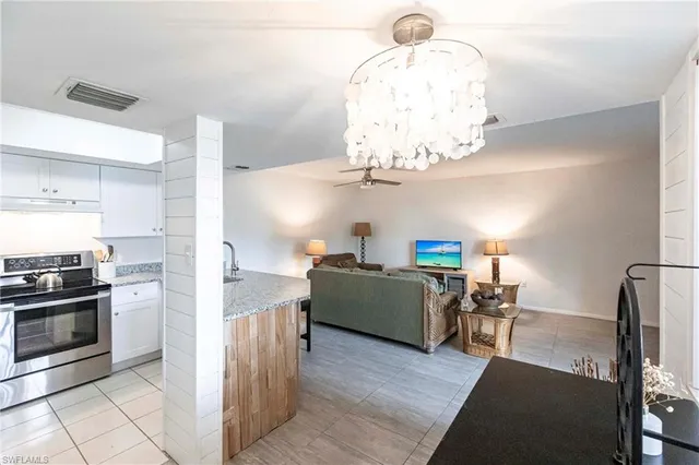 a kitchen with stainless steel appliances granite countertop a sink a stove counter space and cabinets