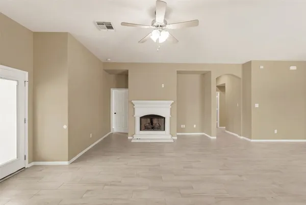 a view of a livingroom with a fireplace a ceiling fan and carpet