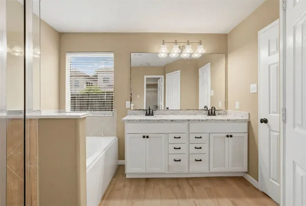 a bathroom with a granite countertop sink a large mirror and a bathtub