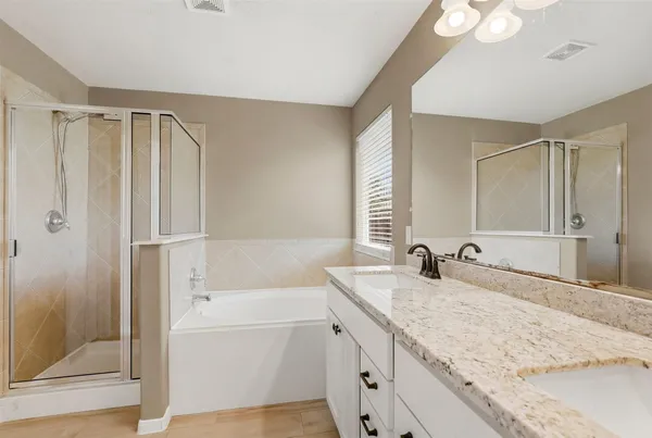 a bathroom with a granite countertop sink mirror and a bathtub