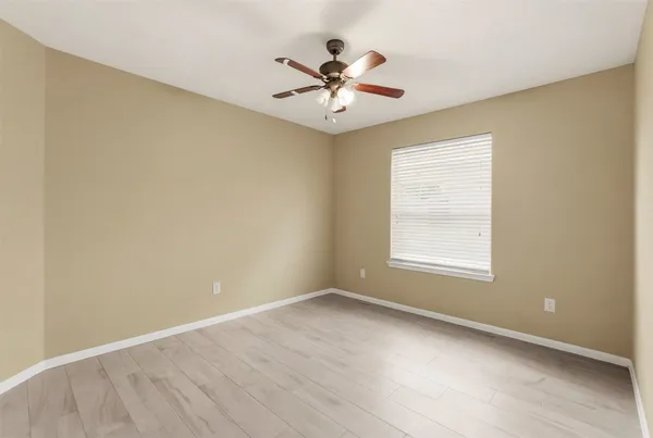 an empty room with a window and a ceiling fan