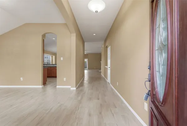 a view of a hallway with wooden floor and staircase