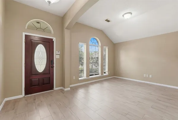 an empty room with mirror and windows