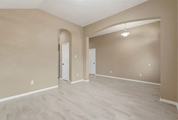 a view of an empty room with wooden floor and closet