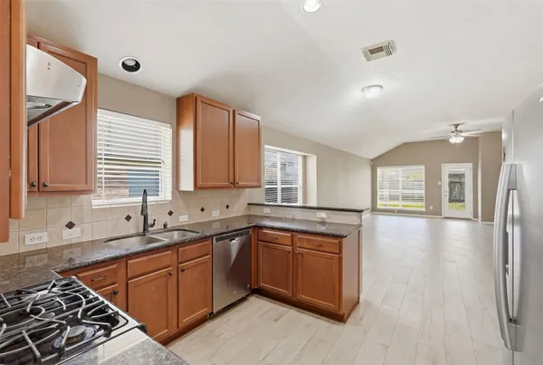 a kitchen with stainless steel appliances granite countertop a sink stove and refrigerator