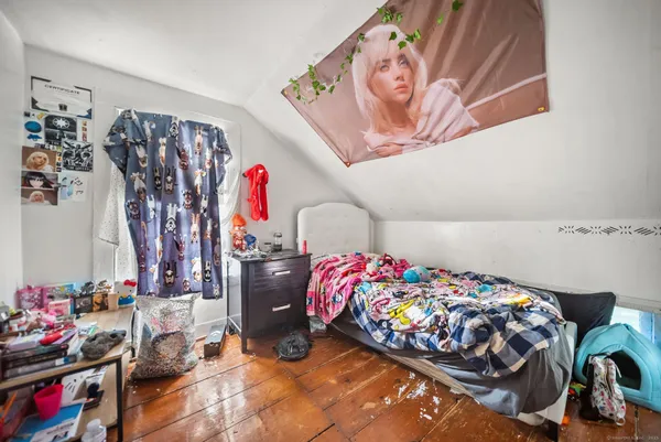a bedroom with bed and wooden floor