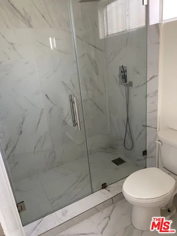 a bathroom with a toilet and a shower