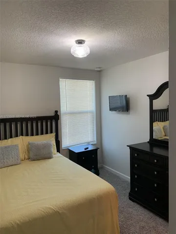 a large bed sitting in a room next to a lamp and a window