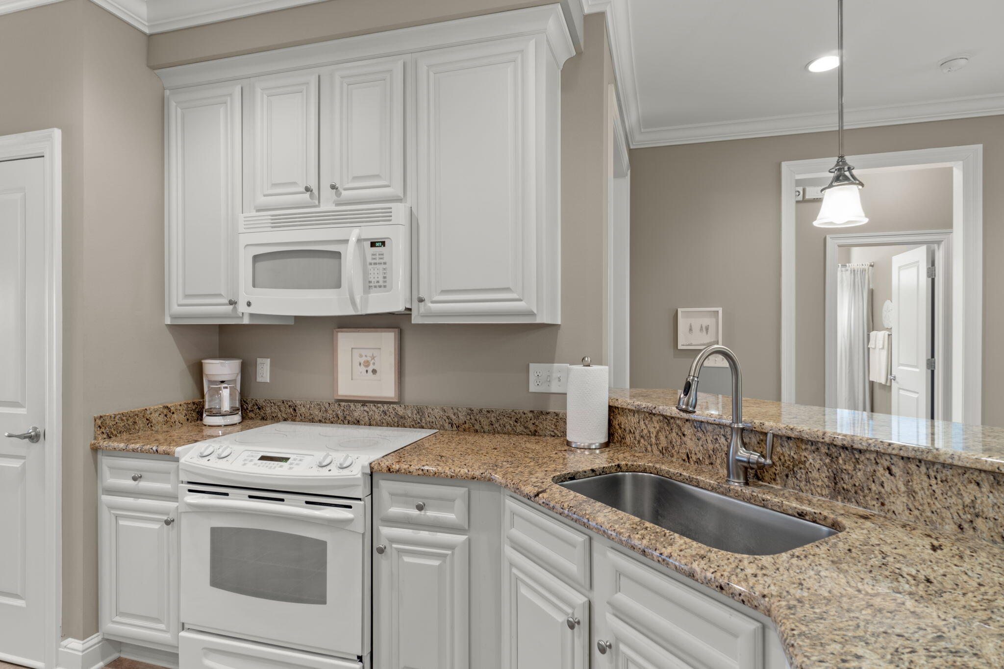562 Falcon Trail Niceville, FL 32578 - Photo 13 of 40 a kitchen with granite countertop a sink a stove and cabinets