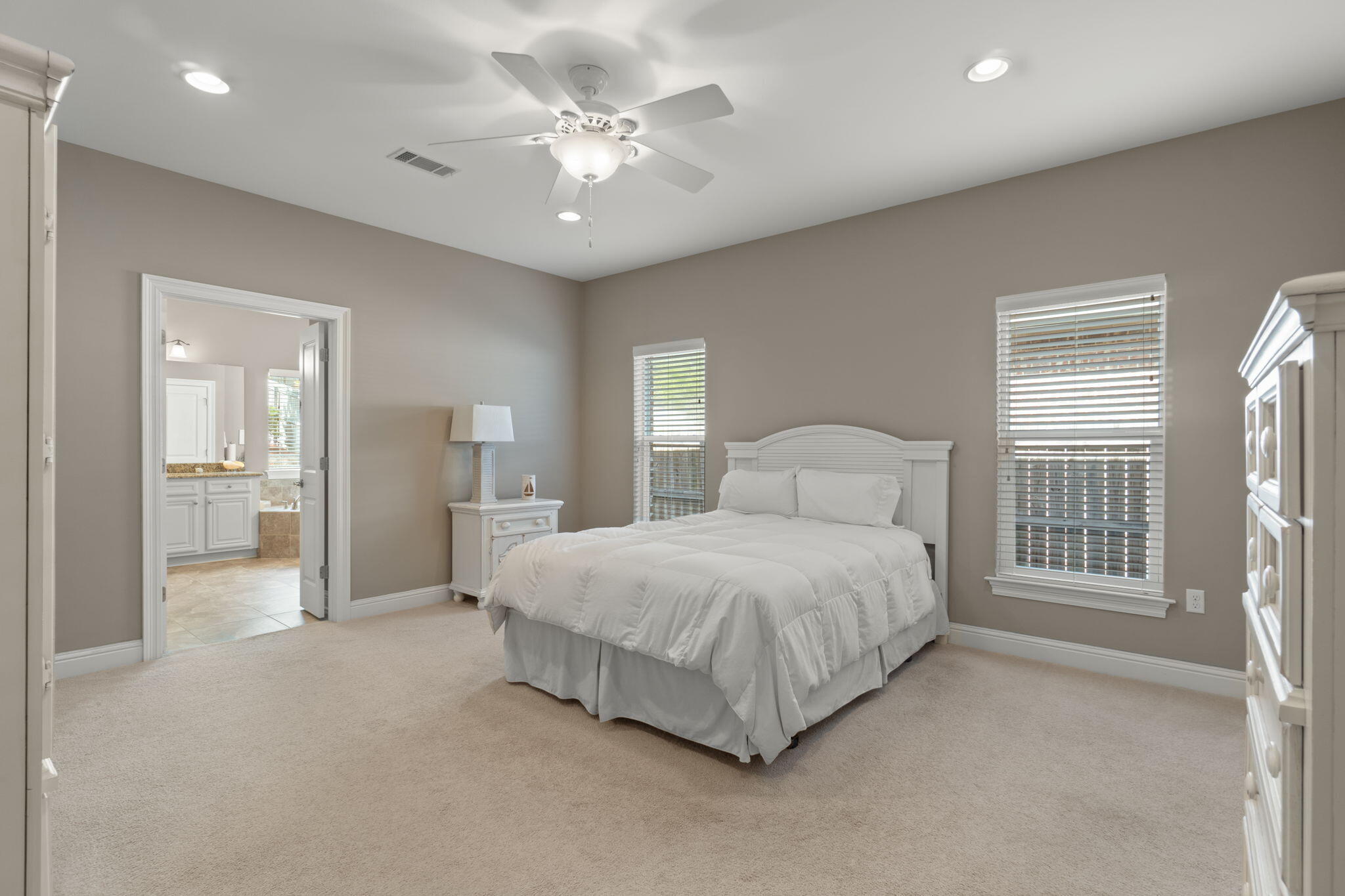 562 Falcon Trail Niceville, FL 32578 - Photo 22 of 40 a spacious bedroom with a large bed and a chandelier