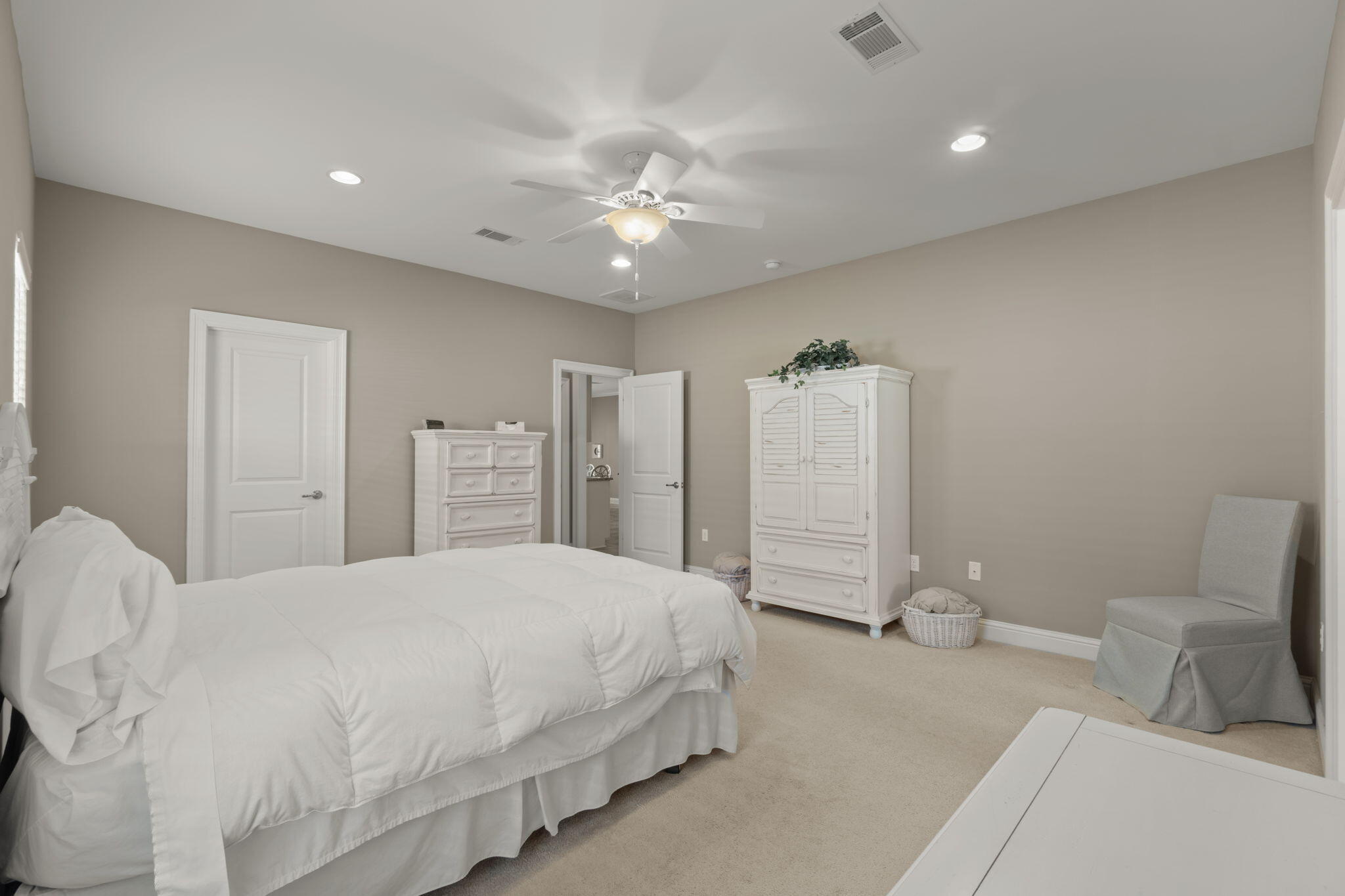 562 Falcon Trail Niceville, FL 32578 - Photo 23 of 40 a bedroom with a large bed and a chandelier
