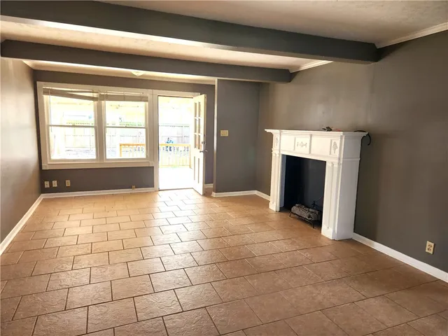 a view of an empty room with a fireplace and a window