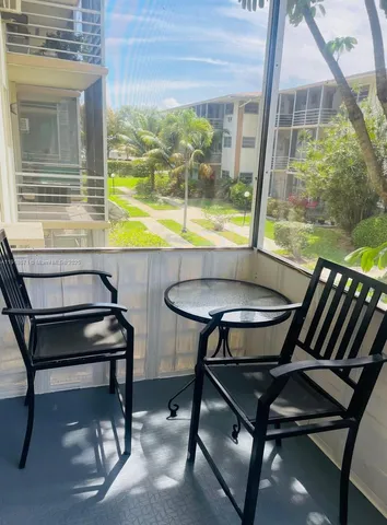 a view of a chairs and table in the balcony