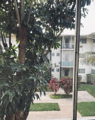 a front view of a house with a yard and a garden