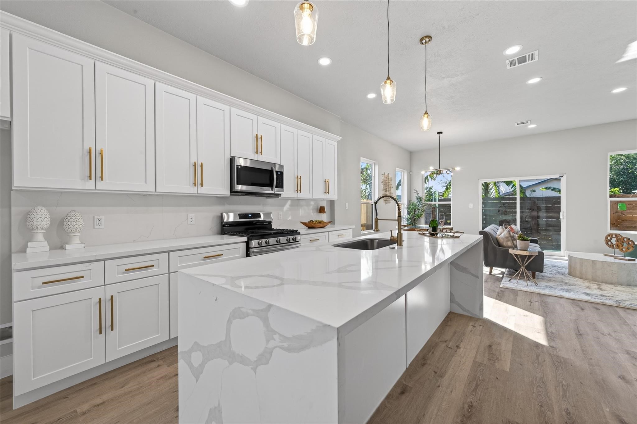 4115 Yale Street Houston, TX 77018 - Photo 16 of 35 Open sightline from kitchen to dining and living areas, enhanced by designer pendant lighting, recessed LEDs, and abundant natural light—perfect for hosting or relaxed daily living.