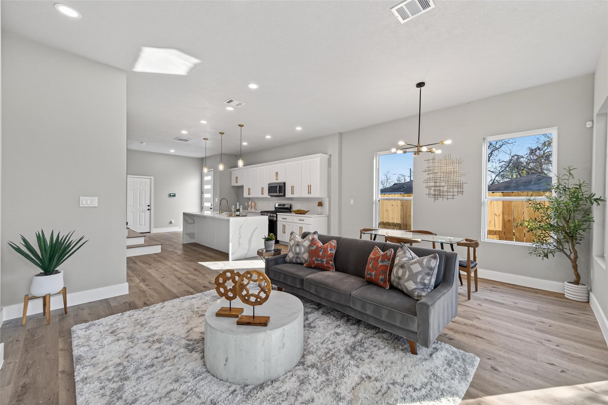 4115 Yale Street Houston, TX 77018 - Photo 21 of 35 Open-concept living and dining area anchored by wide-plank white oak–finish laminate flooring, recessed LED lighting, and windows that flood the space with natural light.