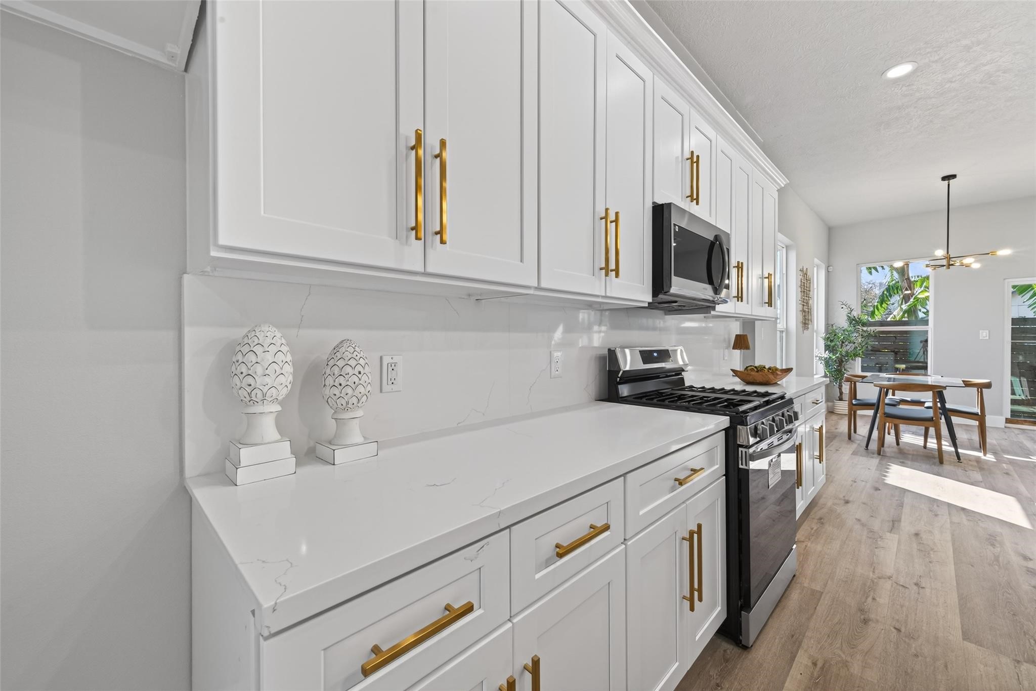 4115 Yale Street Houston, TX 77018 - Photo 8 of 35 Chef-inspired kitchen featuring custom white shaker cabinetry with soft-close drawers, brushed gold hardware, and a full quartz backsplash for a clean, cohesive luxury finish.