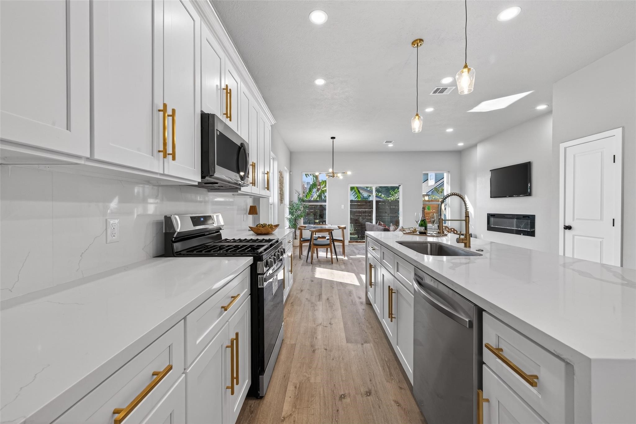 4115 Yale Street Houston, TX 77018 - Photo 10 of 35 Additional kitchen perspective emphasizing high-end stainless steel appliances, generous counter space, and seamless flow to the dining area and outdoor access, ideal for indoor-outdoor entertaining.