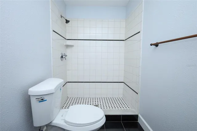 a bathroom with a toilet and a shower