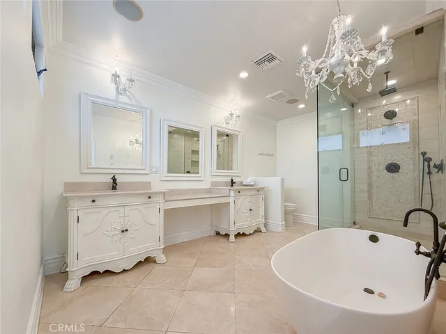 a bedroom with a large bed and a chandelier