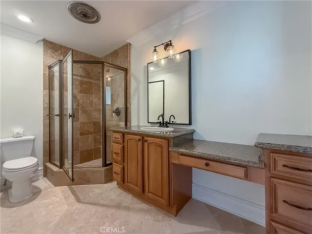 a front view of a house with large trees and wooden fence