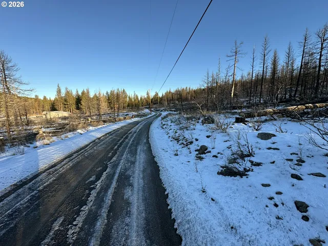 a view of a road with wooden fence
