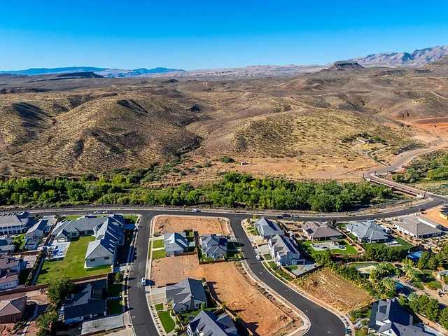 1240 North Gallen Road, Unit 12 Santa Clara, UT 84765 - Photo 2 of 19 Expansive residential development featuring paved streets and established homes, set against a backdrop of natural desert hills and distant mountains