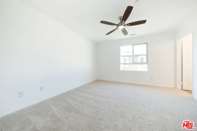 an empty room with a ceiling fan and a window