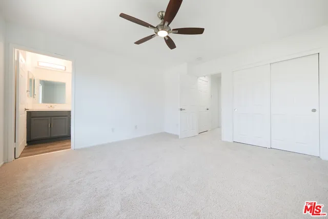 an empty room with ceiling fan and window