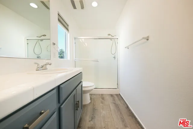 a bathroom with a sink a toilet and shower